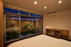 a bedroom with a large window with a fish tank at Hotel Zen in Kyoto