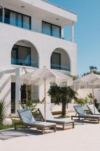 a row of chairs and umbrellas in front of a building at Apartments Stanaj in Ulcinj