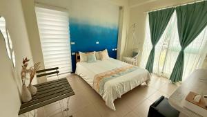 a bedroom with a bed and a bench in it at Burano Yellow Villa in Hengchun South Gate +105 photos