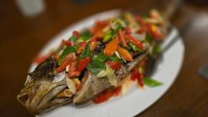 a white plate of food with vegetables on it at Tangkoko Macaca in Rinondoran
