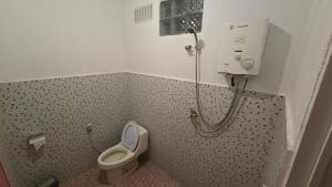 a small bathroom with a toilet and a shower at Tangkoko Macaca in Rinondoran