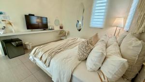 a bedroom with a bed with a television on a wall at Burano Yellow Villa in Hengchun South Gate