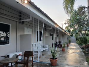a porch of a house with chairs and tables at บ้านในสวนรีสอร์ทBannnaisuan Resort in Prachuap Khiri Khan