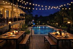 a patio with a table and a pool at night at Baanphet Sukphrom Wang Nam Khiao in Ban Khlong Ta Sang