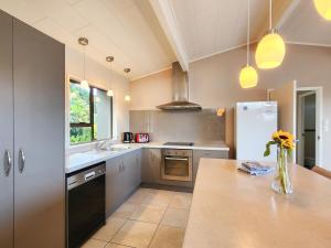 a kitchen with a counter top and a refrigerator at Cathedral Cove Retreat in Hahei