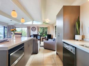a kitchen with a counter and a living room at Cathedral Cove Retreat in Hahei