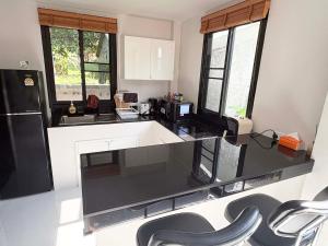 a kitchen with a black and white counter top at Lucky home in the heart of thongsala in Thong Sala