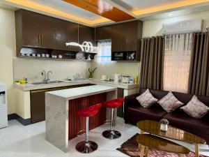 a kitchen and living room with a couch and a table at Henritz Apartelle in Sogod