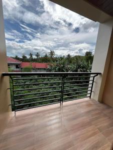 a balcony with a view of palm trees and a sky at Henritz Apartelle in Sogod