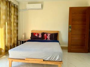 a bedroom with a bed and a wooden door at Henritz Apartelle in Sogod