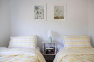 a bedroom with two beds and a side table with a lamp at 1-45 Beech Street in Evans Head