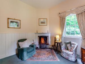 a living room with two chairs and a fireplace at The Ivy Wing in Slickly