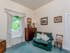 a living room with a green chair and a window at The Ivy Wing in Slickly