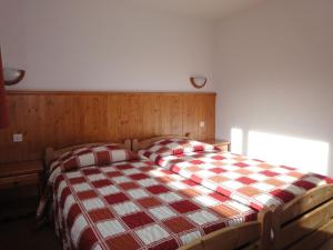 - une chambre dotée d'un lit avec une couverture rouge et blanche en damier dans l'établissement Stylish Apartment in M ribel with Balcony, à Méribel
