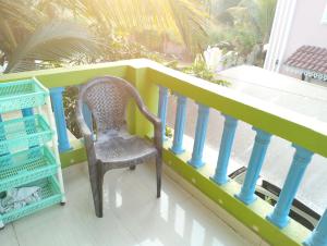 a chair sitting on a balcony next to a railing at Rich nest apartments colva in Colva