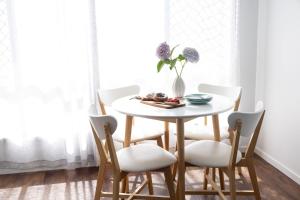 a white table with chairs and a vase with flowers at 2-45 Beech Street in Evans Head