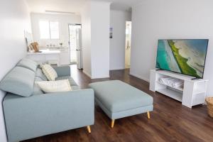 a living room with a couch and a tv at 2-45 Beech Street in Evans Head