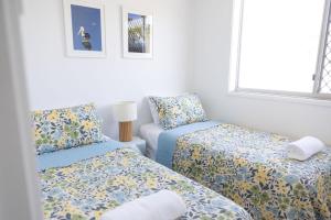 a small room with two beds and a chair at 2-45 Beech Street in Evans Head