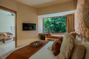 a living room with a large window and a couch at Kai Villas Lombok in Kuta Lombok