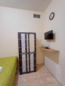 a room with a bed and a tv on a wall at Irma Guest House Syariah in Temenggungan