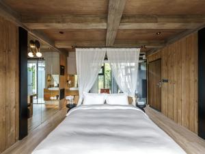a bedroom with a large bed with white sheets at Deer Chaser Hotel - Sun Moon Lake in Yuchi +87 photos