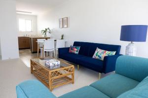a living room with a blue couch and a table at 3-45 Beech Street in Evans Head