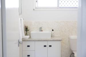 a white bathroom with a sink and a toilet at 3-45 Beech Street in Evans Head +9 photos
