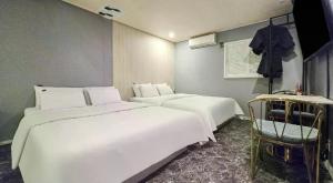 a room with two beds and a chair in it at ZaZaHOTEL in Sosa