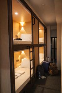 a room with two bunk beds and a mirror at Wink at Perak Road in Singapore