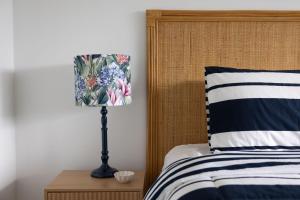 a bedroom with a bed and a lamp on a night stand at 4-45 Beech Street in Evans Head