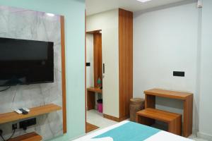 a bedroom with a flat screen tv on a wall at Marine Grand Suite in Cochin