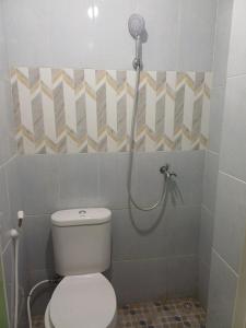 a bathroom with a toilet and a shower at Irma Guest House Syariah in Temenggungan +44 photos