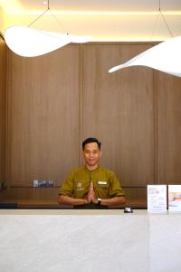 a man is sitting at a table with his tie at Samai Suites in Bandar Lampung