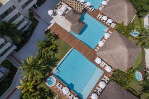 uma vista sobre uma piscina com espreguiçadeiras e palmeiras em Privilege Aluxes Adults Only em Isla Mujeres