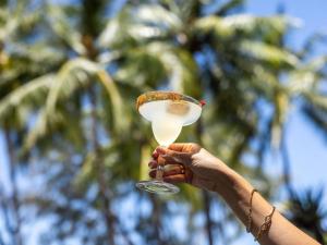 a person holding up a glass with a drink at Peppers Beach Club & Spa in Palm Cove +172 photos