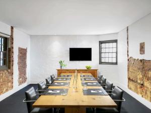 a large conference room with a long table and chairs at Peppers Gallery Hotel in Canberra