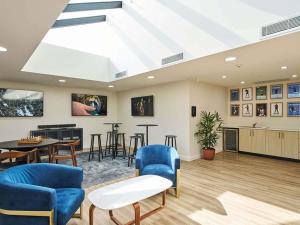 a living room with a skylight and tables and chairs at Mantra Albury in Albury