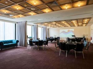 a dining room with tables and chairs in a room at Mantra Albury in Albury