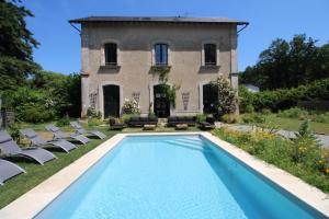 a villa with a swimming pool in front of a house at Petite gare aux oiseaux in Le Châtenet