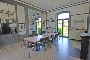 a dining room with a large wooden table and chairs at Petite gare aux oiseaux in Le Châtenet