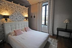 a bedroom with a white bed and a window at Petite gare aux oiseaux in Le Châtenet +23 photos