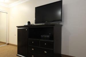 a black dresser with a flat screen tv on top of it at Raincross Hotel Riverside in Riverside