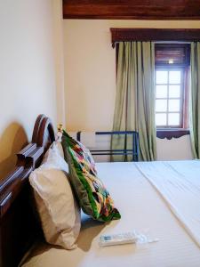 a bedroom with a bed with two pillows on it at Hill Crest Mansion in Kandy