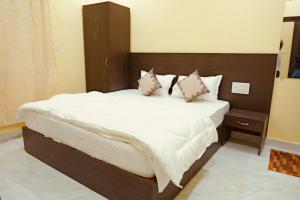 a bedroom with a large bed with white sheets and pillows at Hotel Ramkrishna Stay in Khajurāho