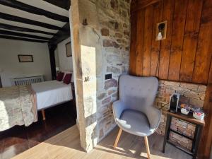 a bedroom with a chair in a room with a bed at CASA RURAL Urruska in Elizondo