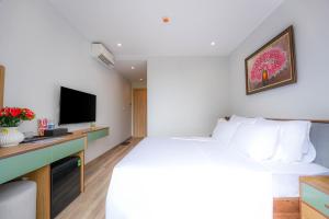 a hotel room with a bed and a tv at Leono Coast Beach Hotel Phu Quoc in Phú Quốc +27 photos