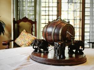 a statue of elephants tied to a barrel on a table at Hill Crest Mansion in Kandy +4 photos