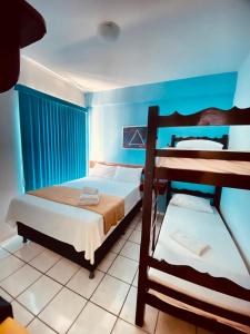 a bedroom with two bunk beds and blue walls at Pousada Oceano Azul in Guarapari