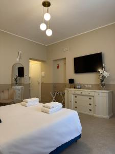 a bedroom with two beds and a tv on the wall at Maison ì room, suite & apartment in Reggio di Calabria