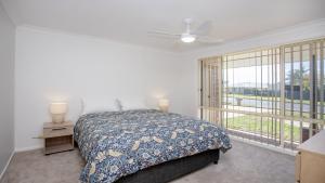 a bedroom with a bed and a large window at Elandra At Old Bar in Old Bar